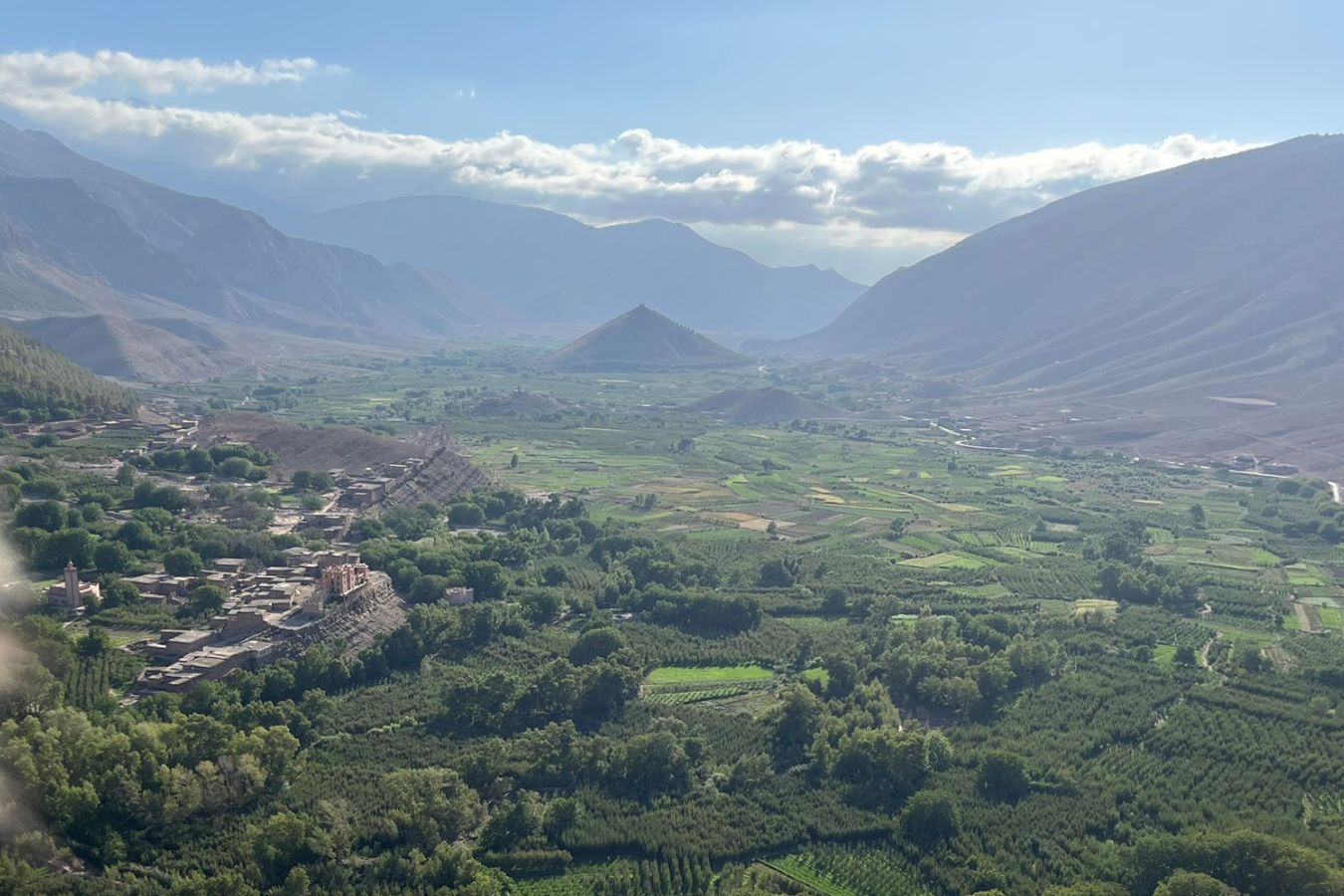 Panoramic view of Aït Bouguemez Valley in the High Atlas Mountains, with terraced fields, Amazigh villages, and surrounding peaks.